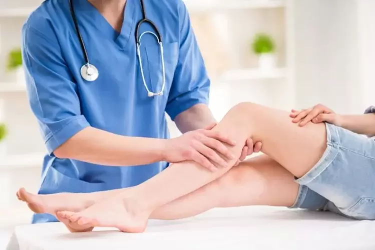 the doctor examines the legs with varicose veins